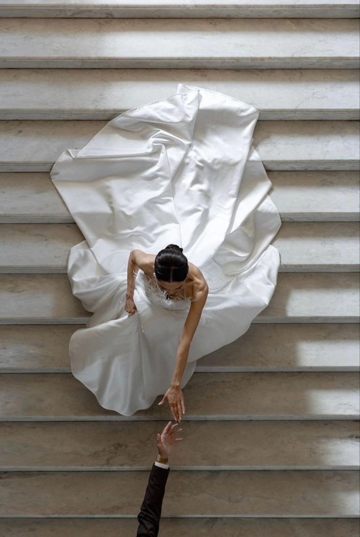 Mariée en robe blanche, descente d’escaliers en marbre vue de haut